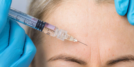 women getting botox on her face to smooth wrinkles