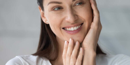 women touching her face after getting a skin tightening treatment