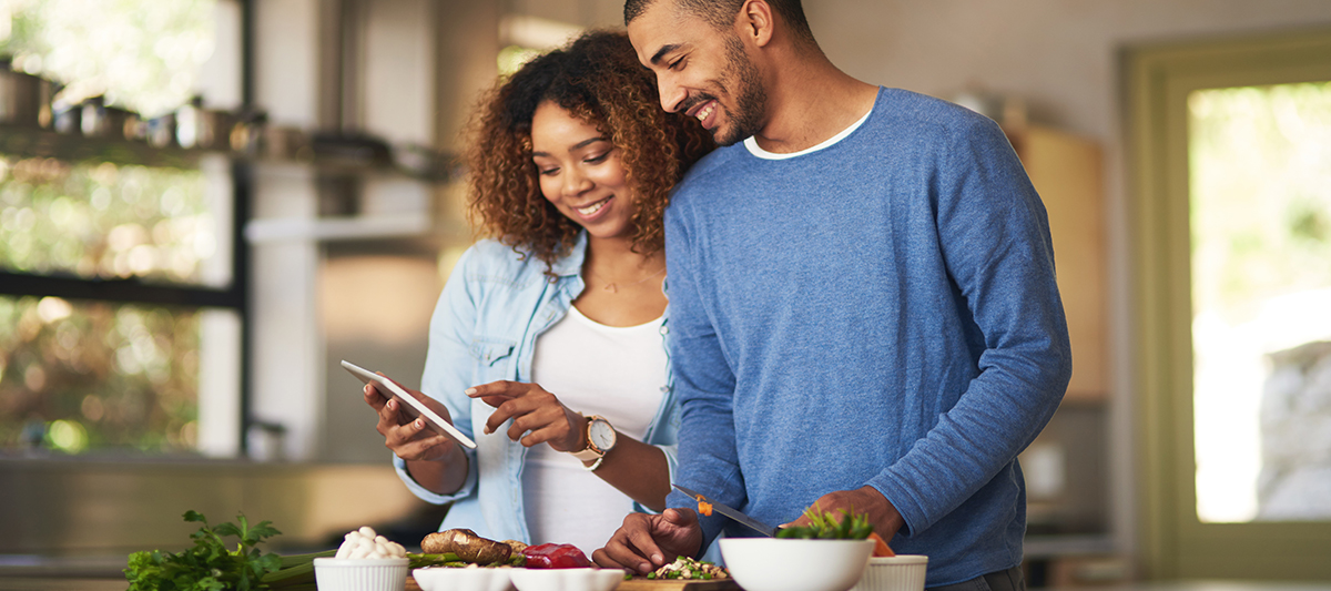 couple making food together while reading a recipe
